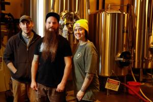 Dave Kolbe, Max Neumann and Savanna Diemer are brewers at Skookum Brewery in Arlington, Washington on January 31, 2022. (Kevin Clark / The Herald)