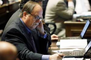 Rep. Mike Sells, D-Everett, takes notes on the House floor at the Capitol in Olympia, Wash., Wednesday, April 13, 2011. The legislative session is scheduled to end later this month. (AP Photo/Ted S. Warren)