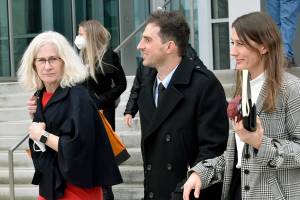 Jared Corson (center), a former Everett police officer, leaves the Snohomish County Courthouse with his wife, Erika Corson (right), and defense attorney Karen Halverson (left) during a break in his trial Tuesday. (Ellen Dennis / The Herald) Feb. 8, 2022