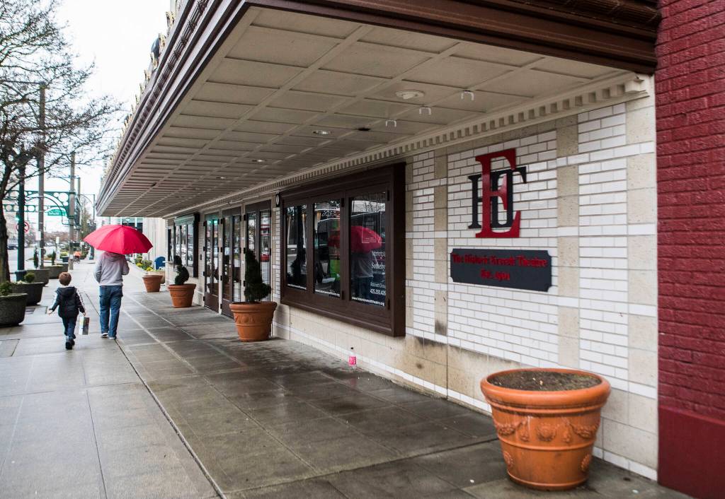 People walk down the sidewalk in front of the Historic Everett Theatre. (Olivia Vanni / The Herald)
