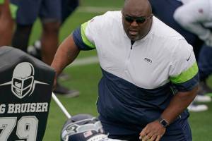 Seattle Seahawks defensive line and assistant head coach Clint Hurtt, right, runs a drill during NFL football practice Tuesday, June 15, 2021, in Renton, Wash. (AP Photo/Ted S. Warren)