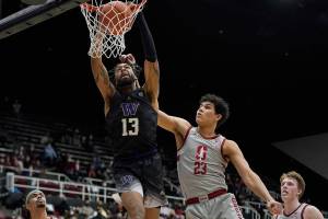 Washington forward Langston Wilson (13) dunks against Stanford forward Brandon Angel (23) during the second half of an NCAA college basketball game in Stanford, Calif., Sunday, Feb. 6, 2022. (AP Photo/Jeff Chiu)
