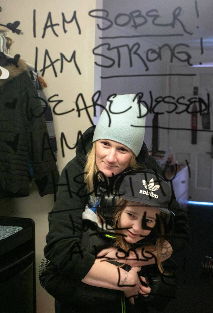 Melinda Parke holds her son, Elijah, inside their room at the Days Inn on Friday in Everett. Melinda is in recovery for substance abuse and has affirmations written on her bathroom mirror. (Ryan Berry / The Herald)