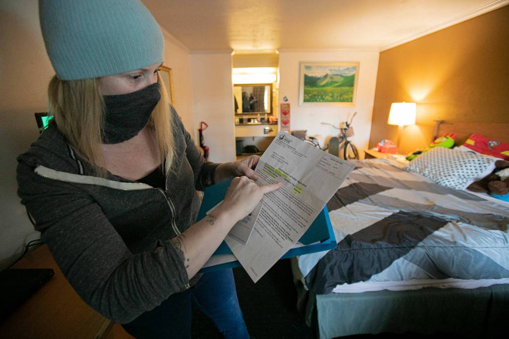 Melinda Parke shows her application to the King County Housing Authority while in her motel room in Everett. (Ryan Berry / The Herald)
