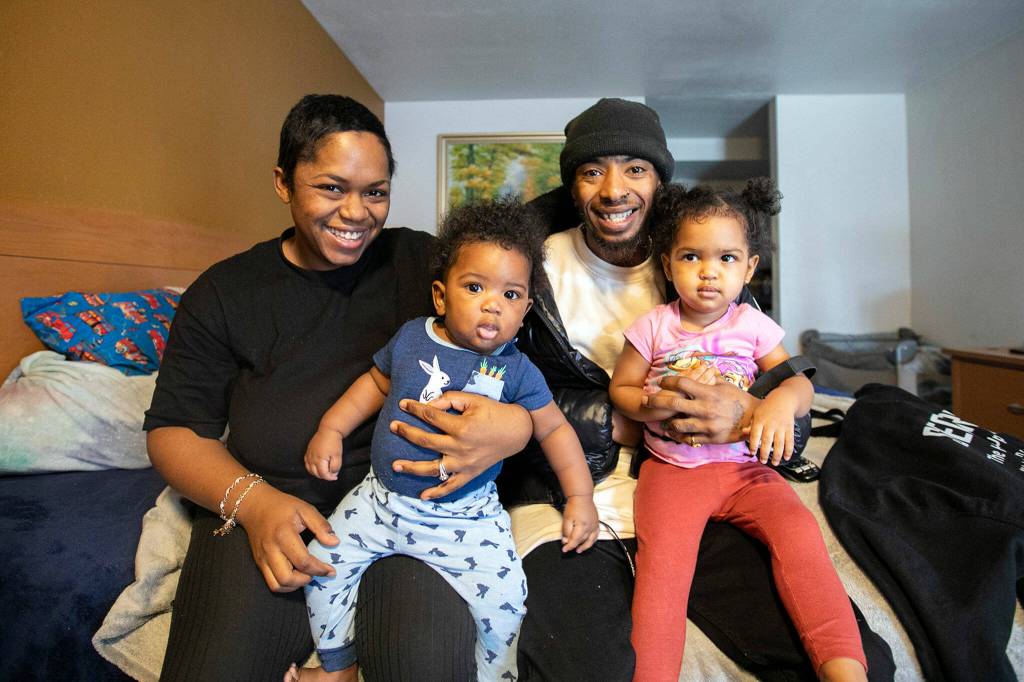Latina Banks and Dameon Smith in their motel room with their children, Tzion Smith, 6 months, and Ariel Banks, 2, at the Days Inn in Everett. (Ryan Berry / The Herald)