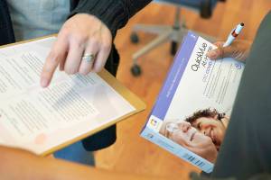 Kristin Travis, a community outreach doula, holds a home COVID-19 test kit Thursday, Feb. 3, 2022, while picking up supplies at Open Arms Perinatal Services before going out to visit some of her clients in Seattle.  With the brutal omicron wave rapidly easing its grip, new cases of COVID-19 in the U.S. are falling in 49 of the 50 states. (AP Photo/Ted S. Warren)