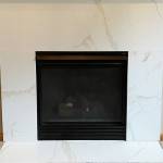 The Granite Transformations team refaced the fireplace surround in the same material as the kitchen for a modern, cohesive look.