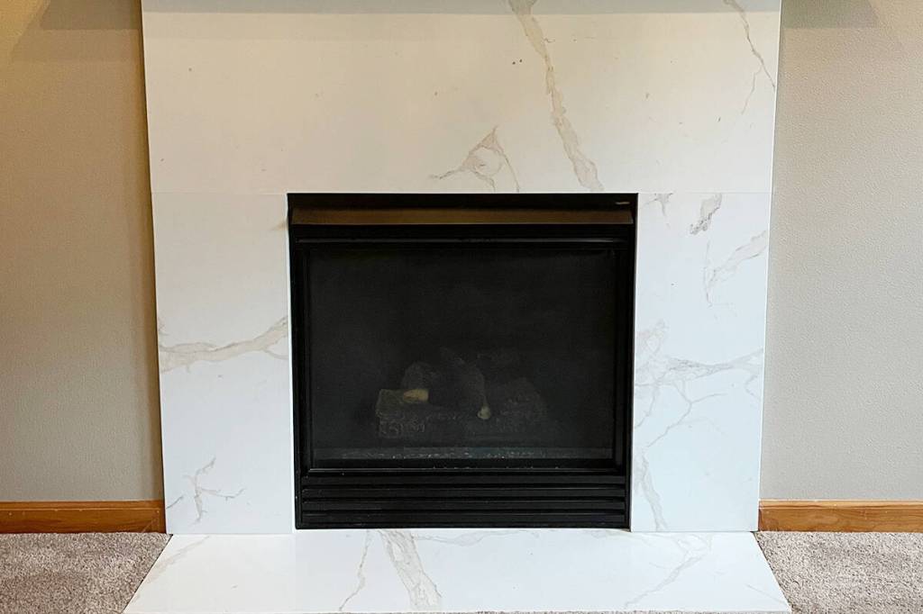 The Granite Transformations team refaced the fireplace surround in the same material as the kitchen for a modern, cohesive look.
