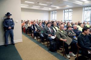 A Washington State Patrol trooper stands watch Tuesday, Feb. 25, 2020 as a capacity audience listens to testimony at a public hearing at the Capitol in Olympia, Wash. on a new bill that would ban high-capacity gun magazines in Washington state. (AP Photo/Ted S. Warren)