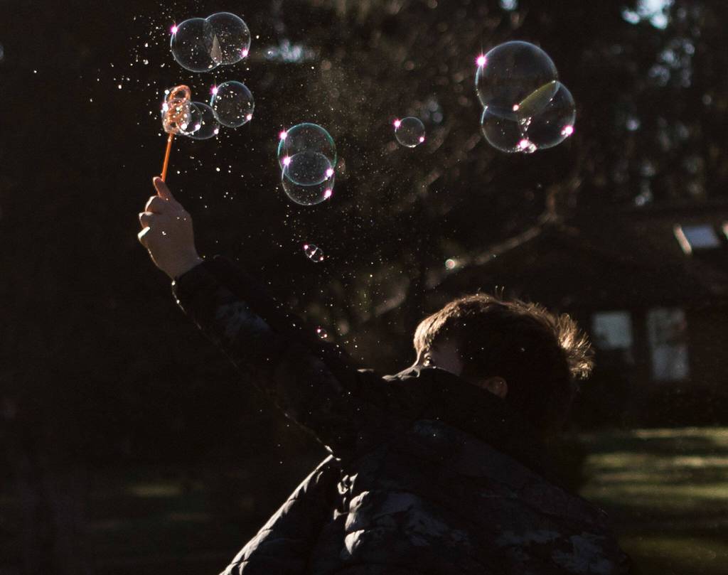 Jacob, 9, plays with bubbles in the front yard of his home in Everett. (Olivia Vanni / The Herald)