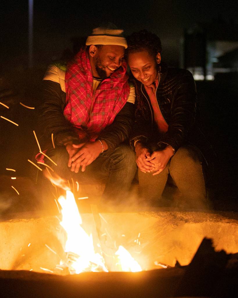 Mike Njeri and Angela Ritho sit fireside together along the beach of Lighthouse Park on Feb. 9 in Mukilteo. The two friends were celebrating Njeris birthday, which was the following day. Njeri didnt disclose his age, to keep it a secret, he said, laughing. (Ryan Berry / The Herald)