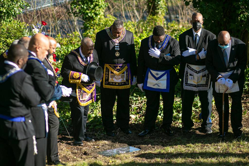 Members of Prince Hall Mason lodges throughout the state Friday pray over the grave of Ben Lewis at Evergreen Cemetery in Everett. (Ryan Berry / The Herald)