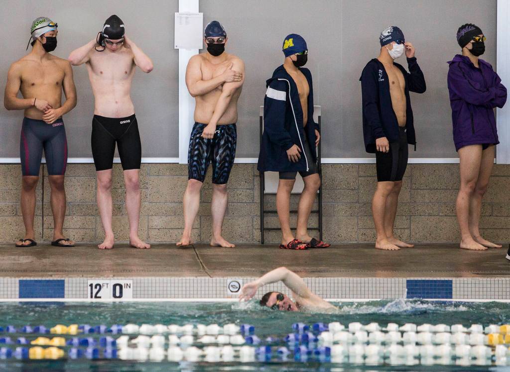 Swimmers wait for their race to start during the 4A Boys Districts swim meet on Saturday, Feb. 12, 2022 in Snohomish, Wa. (Olivia Vanni / The Herald)