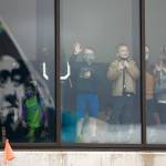 People inside the airport wave to passengers aboard the first Alaska Airlines Boeing 737 arrival Thursday at Paine Field Airport in Everett. (Ryan Berry / The Herald)