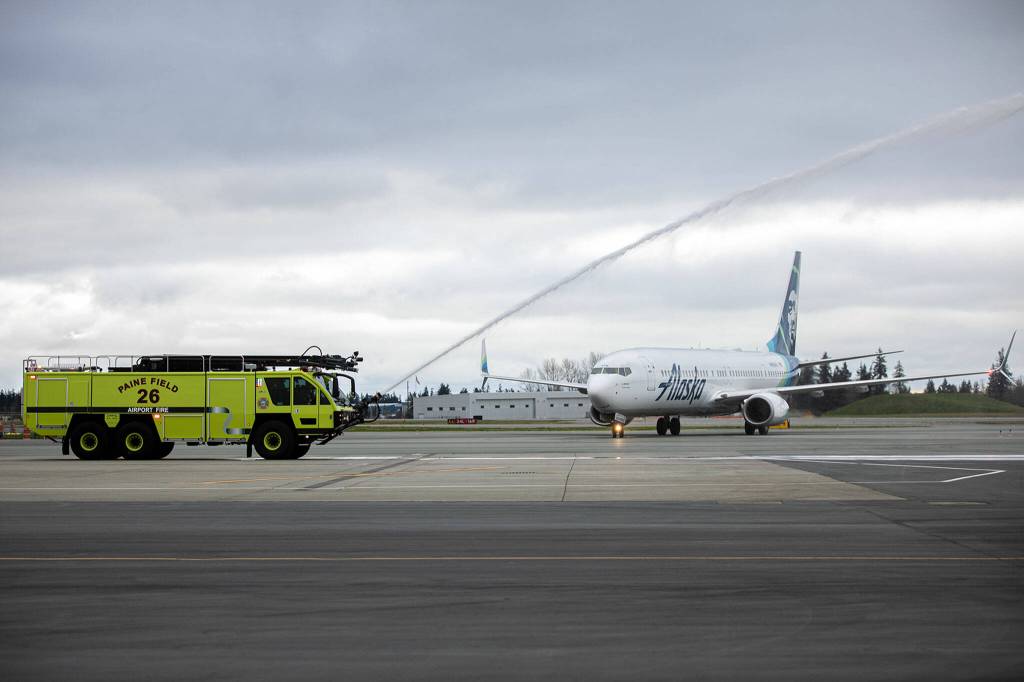An Alaska Airlines Boeing 737 is given a water salute after landing Thursday at Paine Field in Everett. (Ryan Berry / The Herald)