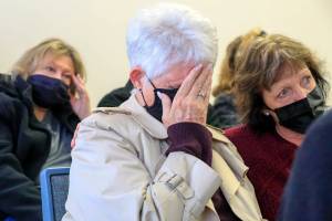 Lynn Sass, center, with Kim Cutts, right, listens as the judge hands down the sentence of Mark Abrahamson Monday afternoon at the Snohomish County Superior Courthouse in Everett, Washington on February 14, 2022.  (Kevin Clark / The Herald)