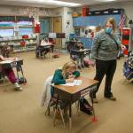 Third grade teacher Lisa Thompson walks by her ten students, separated at six-foot distance, at Eagle Creek Elementary on Wednesday, Jan. 27, 2021 in Arlington, Washington. The students wear masks, are six feet from each other in class and after recess ends, get a mask break. (Andy Bronson / The Herald)