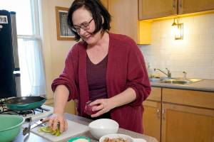 Using leftover pork from earlier in the week, Haley Nelson creates tacos, Thursday, Feb. 3, 2022 in the kitchen of her home in St. Paul, Minnesota. Nelson has run her Cheap Recipe Blog for more than a decade, sharing ways to shop and cook cheaply. One of her tips is cooking meat and repurposing it throughout the week in several recipes. (Shari L. Gross/Minneapolis Star Tribune/TNS)