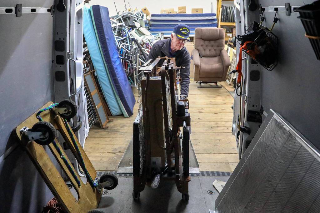 Richard Marin loads a bed for delivery Tuesday afternoon at the MSHH Donor Closet in Edmonds. (Kevin Clark / The Herald)
