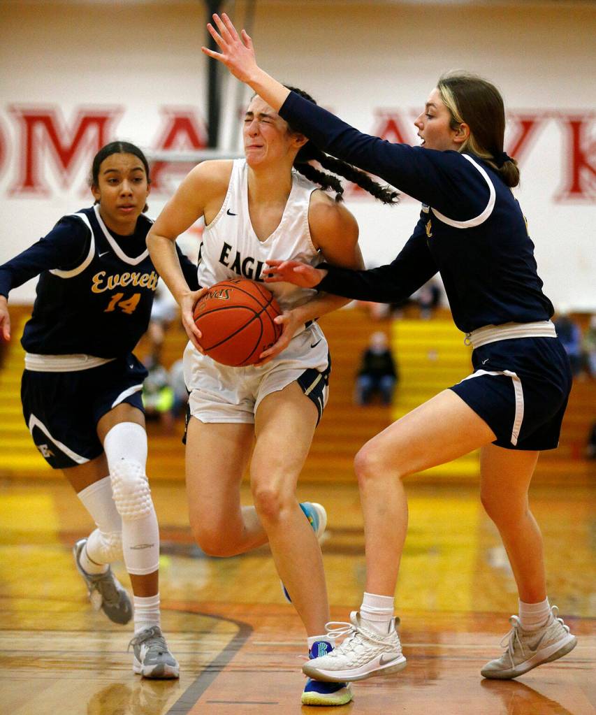 Arlingtons Jenna Villa makes her way to the basket through a crowd against Everett Tuesday, Feb. 15, 2022, at Marysville Pilchuck High School in Marysville, Washington. (Ryan Berry / The Herald)