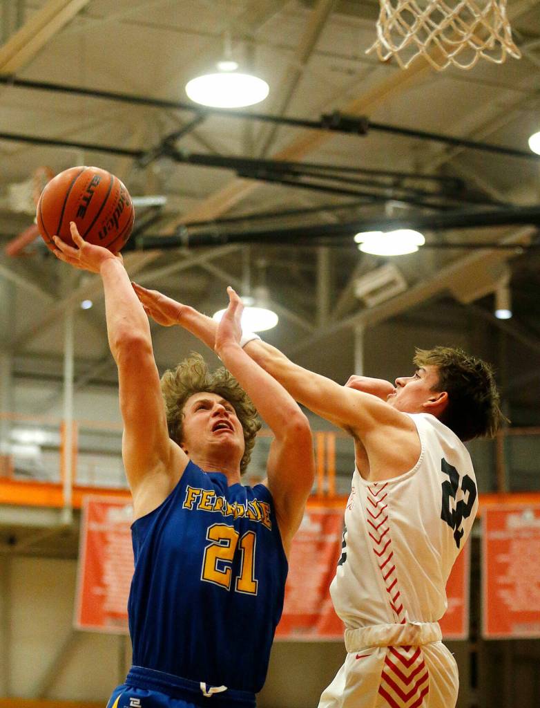 Ferndales Conner Walcker puts up a contested shot against Stanwood during a 3A District 1 Tournament semifinal game on Wednesday at Everett Community College. (Ryan Berry / The Herald)