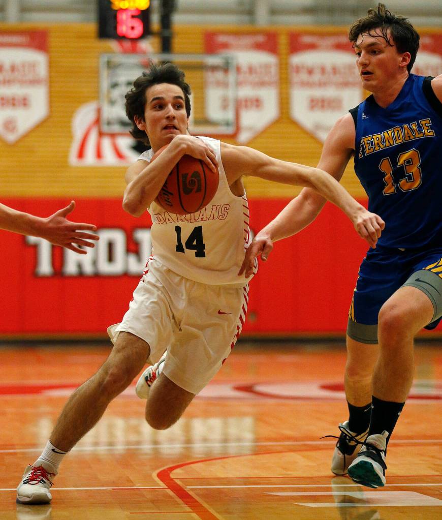 Stanwoods Max Mayo cradles the ball on the way to the basket against Ferndale during a 3A District 1 Tournament semifinal game on Wednesday at Everett Community College. (Ryan Berry / The Herald)