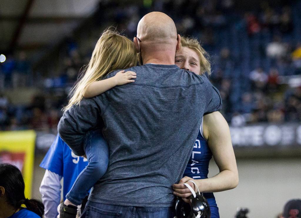Glacier Peaks Karianne Baldwin is hugged by Glacier Peak coach Jordan Gere after winning the Girls 125-pound championship match at the Mat Classic XXXIII on Saturday in Tacoma. (Olivia Vanni / The Herald)