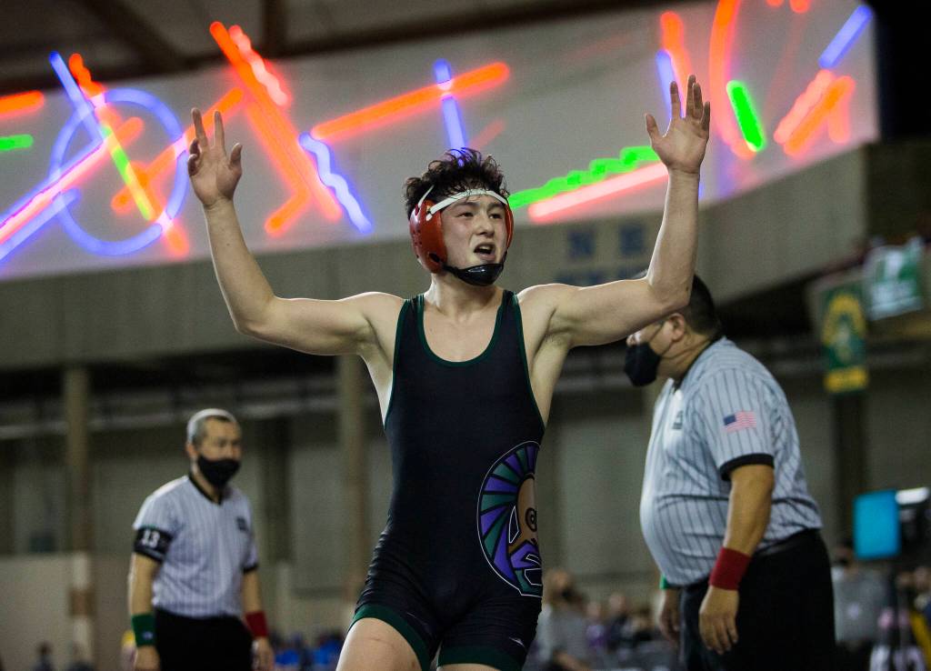 Edmonds-Woodways Alex Rapelje lifts his arms in celebration after winning the 3A Boys 152-pound championship match at the Mat Classic XXXIII on Saturday in Tacoma. (Olivia Vanni / The Herald)