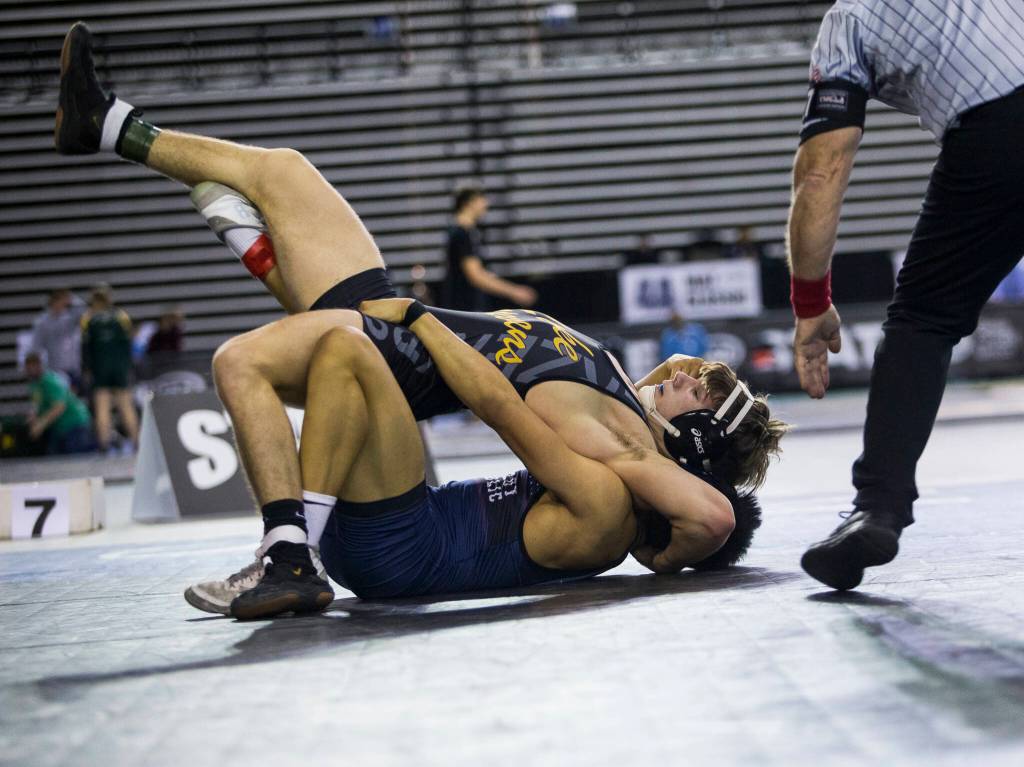 Lake Stevenss Wyatt Springer tries to escape a pinning during his 4A 160-pound championship match against Kennedys Mateo De La Pena at Mat Classic XXXIII on Saturday in Tacoma. (Olivia Vanni / The Herald)