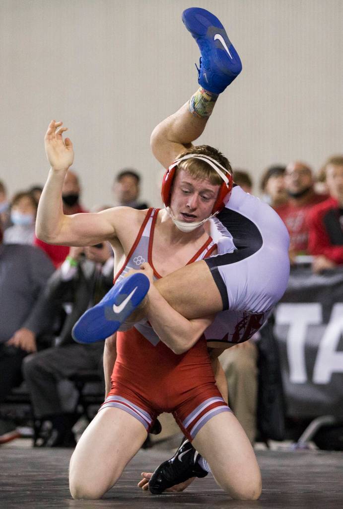 Stanwoods Tyler Rhue flips North Centrals Kenndyl Mobley during the 3A 126-pound championship match at the Mat Classic XXXIII on Saturday in Tacoma. (Olivia Vanni / The Herald)