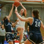 Everetts Emma Larson pulls up for a floater with Meadowdales Jordan Leith, left, and Ava Powell defending Saturday afternoon at during the 3A District Tournament at Everett Community College in Everett, Washington on February 19, 2022. (Kevin Clark / The Herald )
