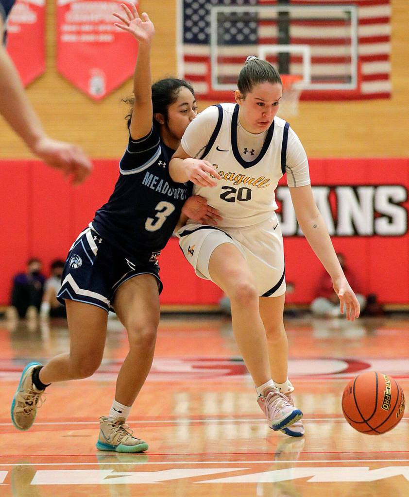 Everetts Ella Sylvester controls the dribble with Meadowdales Jenaly Gabriel adding pressure Saturday afternoon at during the 3A District Tournament at Everett Community College in Everett, Washington on February 19, 2022. (Kevin Clark / The Herald )