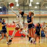 Everett’s Alana Washington attempts an underhand layup with Meadowdale’s McKenna Kuecker trailing Saturday afternoon at during the 3A District Tournament at Everett Community College in Everett, Washington on February 19, 2022. (Kevin Clark / The Herald )