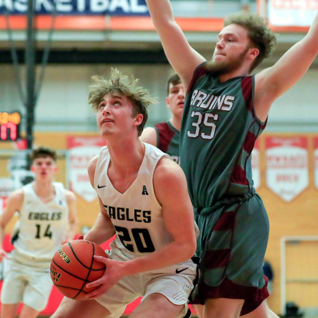 Arlingtons Gage Price looks to score with Cascades Kolten Monteith defending Saturday afternoon at during the 3A District Tournament at Everett Community College in Everett, Washington on February 19, 2022. (Kevin Clark / The Herald )