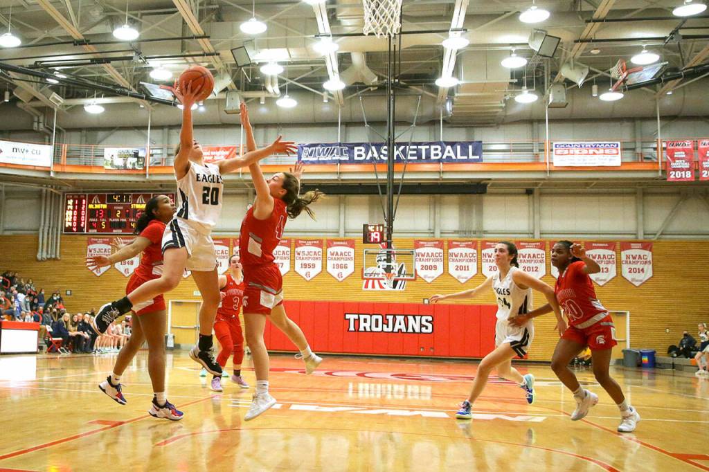 Arlingtons Samara Morrow attempts a shot over Stanwoods Paige Almanza Saturday evening at during the 3A District 1 Title game at Everett Community College in Everett, Washington on February 19, 2022. (Kevin Clark / The Herald )