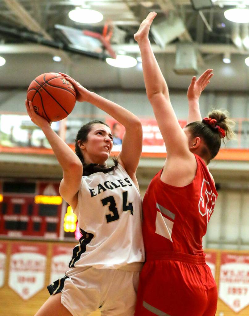 Arlingtons Jenna Villa looks to score with Stanwoods Vivienne Berrett defending Saturday evening at during the 3A District 1 Title game at Everett Community College in Everett, Washington on February 19, 2022. (Kevin Clark / The Herald )