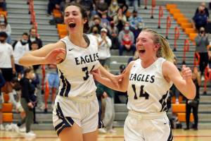 Arlington's Jenna Villa and Keira Marsh celebrate in the closing second of play Saturday evening at during the 3A District 1 Title game against Stanwood at Everett Community College in Everett, Washington on February 19, 2022. (Kevin Clark / The Herald )