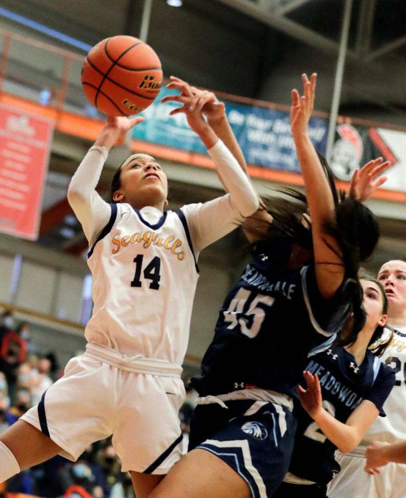 Everetts Mae Washington (left) gathers a loose ball with Meadowdales Samantha Medina defending during a 3A District 1 Tournament game this past Saturday at Everett Community College. (Kevin Clark / The Herald)