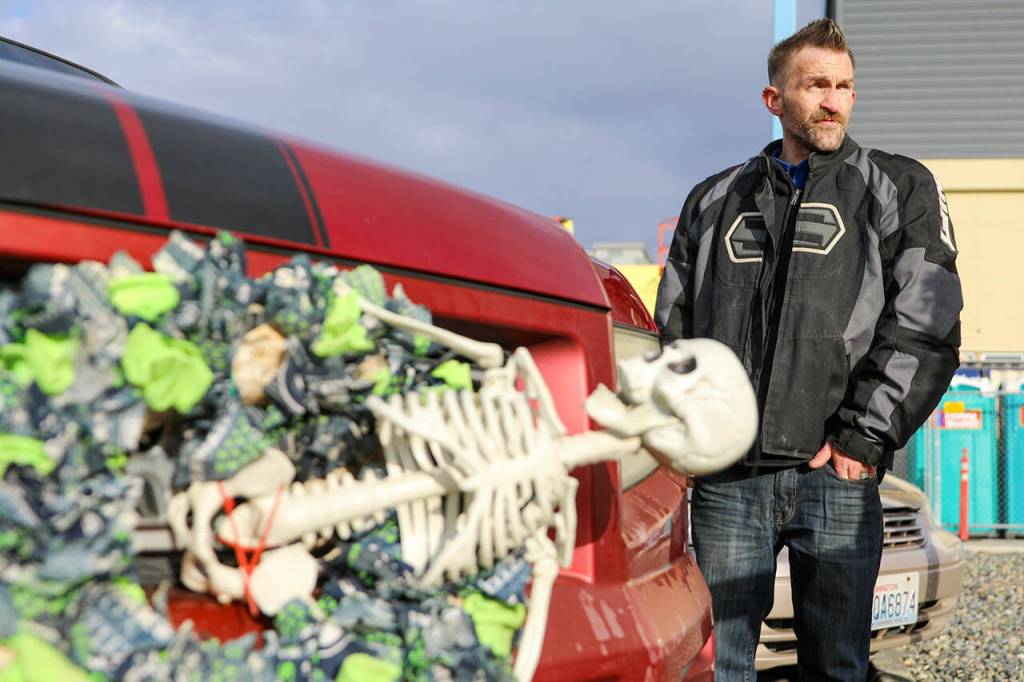 Glenn Griswold stands near his skeleton-decorated truck in Everett on Tuesday. (Kevin Clark / The Herald )