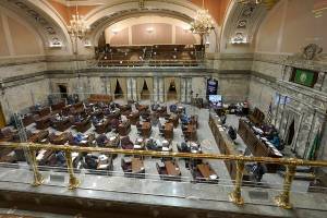 Legislators work on the Washington Senate floor at the Capitol in Olympia, Wash., on Tuesday, Feb. 15, 2022, during debate over a measure that authorizes legislative leaders to terminate any state of emergency called by the governor after 90 days if the Legislature is not in session. The measure passed the Democratic-led Senate chamber and now heads to the House, also held by Democrats, for consideration. (AP Photo/Ted S. Warren)