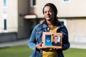 Meseret Haile displays a photo of her son Leoul outside her apartment in Bellevue. Leoul, who has special needs, is in a facility in Kansas because Washington doesn't have adequate
facilities. (Dan DeLong/InvestigateWest)
