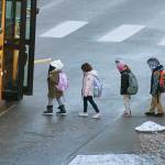 Children board a school bus in Everett on Thursday morning. (Sue Misao / The Herald) Feb. 24, 2022