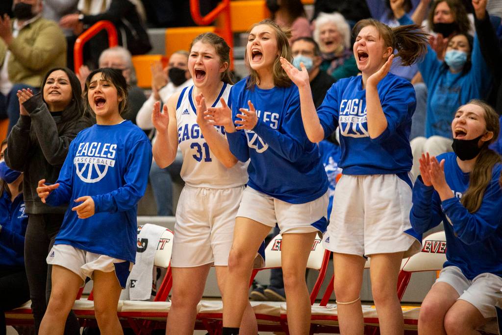 The Grace Academy bench reacts to a three point shot during the game against Cusick on Friday, Feb. 25, 2022 in Everett, Washington. (Olivia Vanni / The Herald)