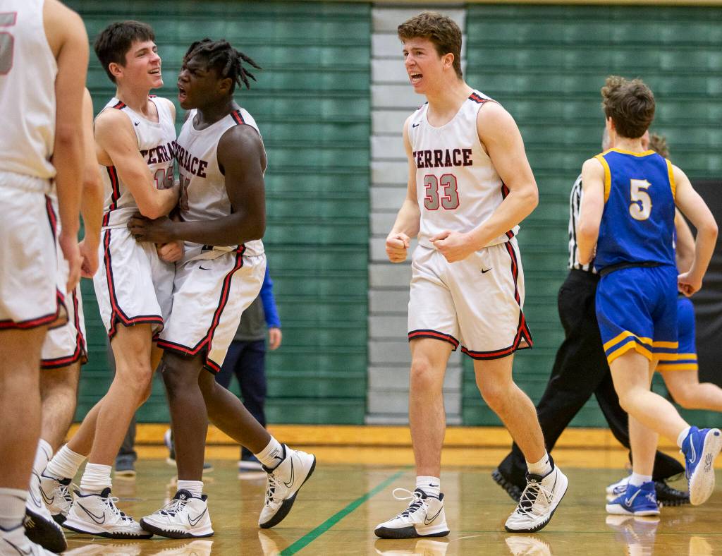 Olivia Vanni / The Herald
Mountlake Terraces Adison Mattix (33), Zaveon Jones (second from left) and Jaxon Dubiel (left) react after sending a 3A state tournament game against Kelso into overtime on Saturday at Jackson High School in Mill Creek. Mountlake Terrace overcame a 14-point deficit to win 67-65 in overtime.