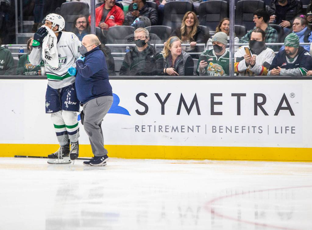 Fans take photos and react to a large pool of blood on the ice during the game at Climate Pledge Arena on Saturday, Feb. 26, 2022 in Seattle, Washington. (Olivia Vanni / The Herald)