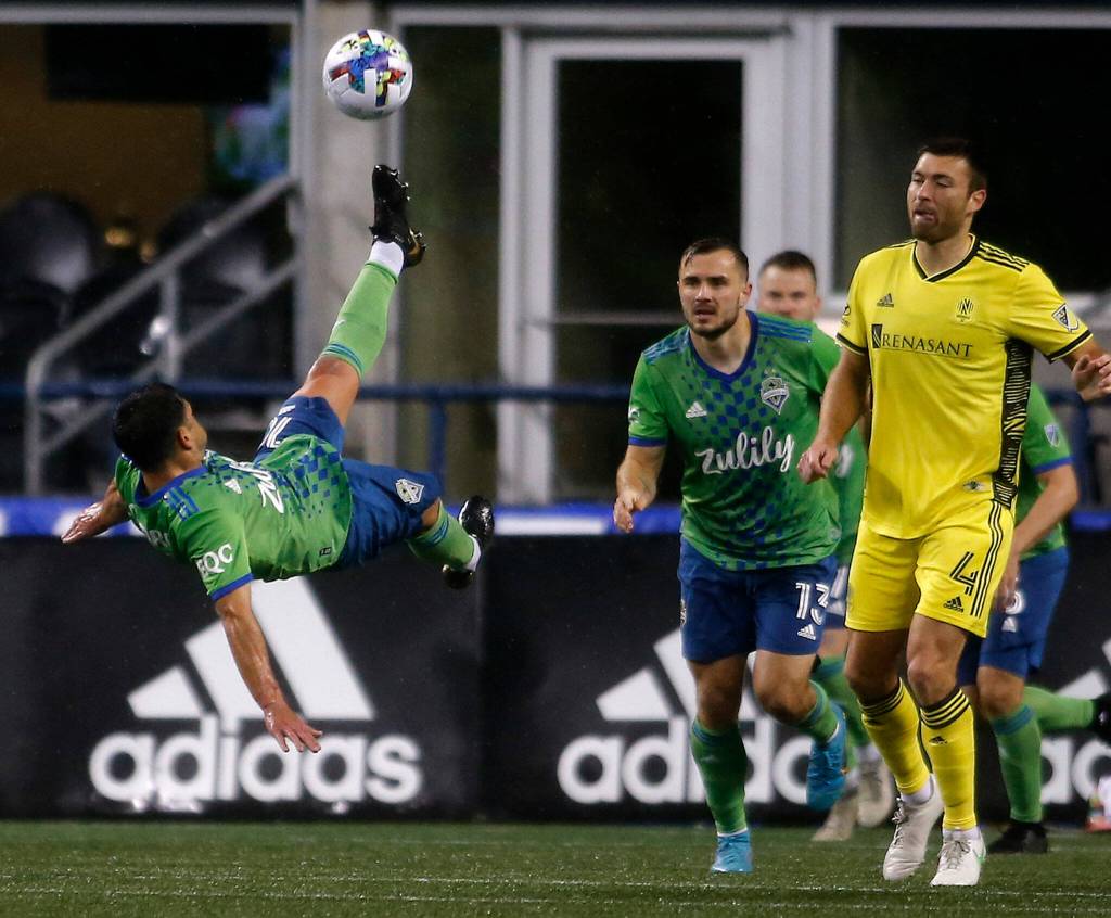 The Seattle Sounders’ Nicolas Lodeiro bicycle kicks the ball out of harm’s way during the opening game of the 2022 season against Nashville SC on Sunday, Feb. 27, 2022, at Lumen Field in Seattle, Washington. (Ryan Berry / The Herald)