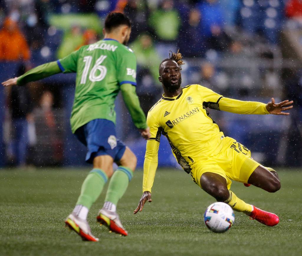 Nashville SCs CJ Sapong tries to make a sliding tackle during the opening game of the 2022 season against Seattle on Sunday, Feb. 27, 2022, at Lumen Field in Seattle, Washington. (Ryan Berry / The Herald)