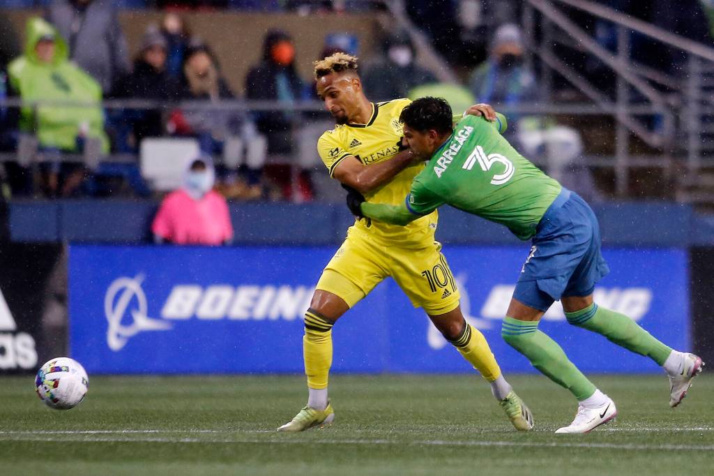 The Seattle Sounders Xavier Arreaga fights with Nashvilles Hany Mukhtar for the ball during the opening game of the 2022 season against Nashville SC on Sunday, Feb. 27, 2022, at Lumen Field in Seattle, Washington. (Ryan Berry / The Herald)