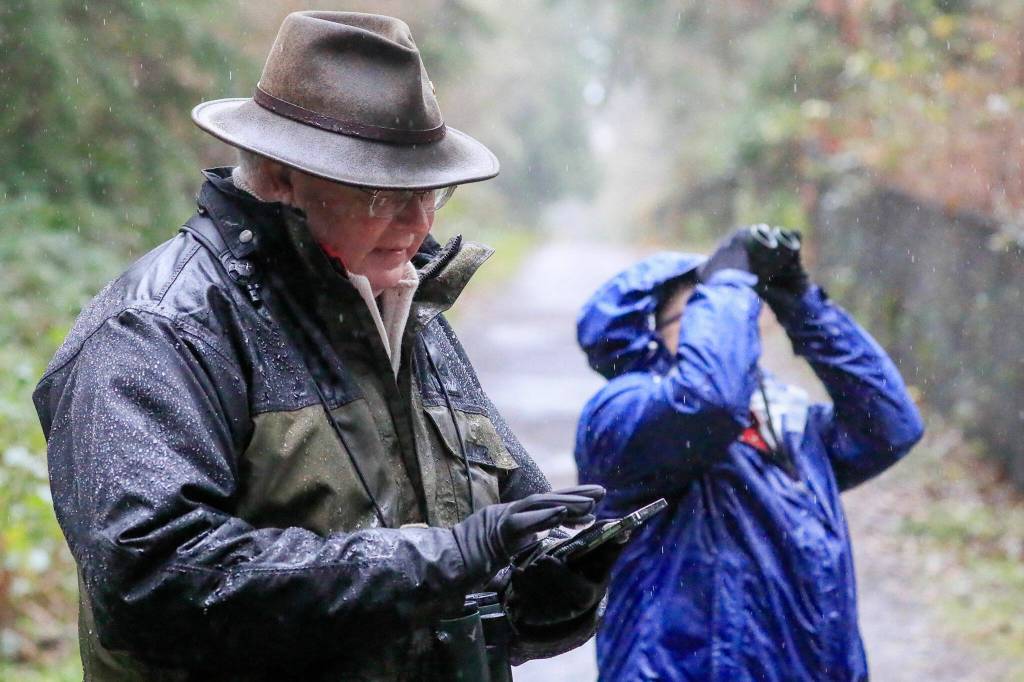 Rick Taylor enters the birds found on a smartphone along the trail at Willis Tucker Park with his wife, Tina Taylor. (Kevin Clark / The Herald)