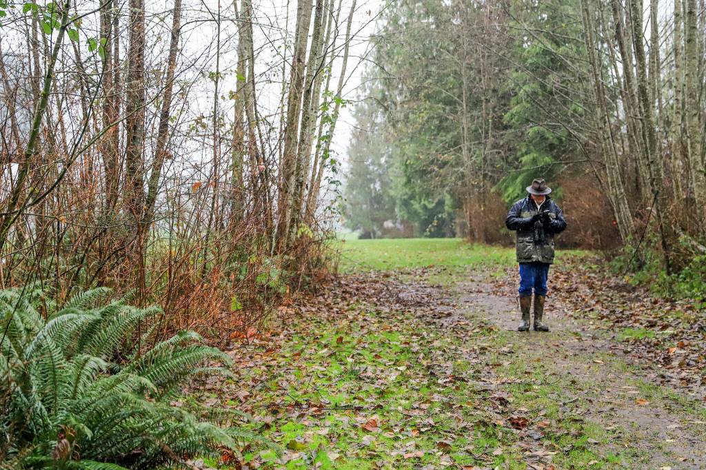 Rick Taylor enters the birds found on a smartphone along the trail. (Kevin Clark / The Herald)